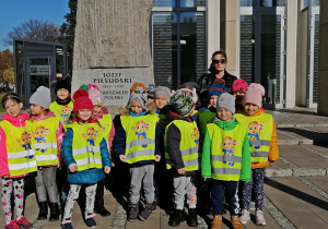 Dzieci stoją przed pomnikiem Józefa Piłsudskiego